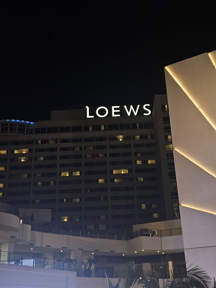 Fachada iluminada do Loews Hollywood Hotel durante a noite.